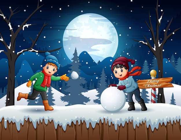 Niños de dibujos animados jugando bola de nieve en la noche de invierno