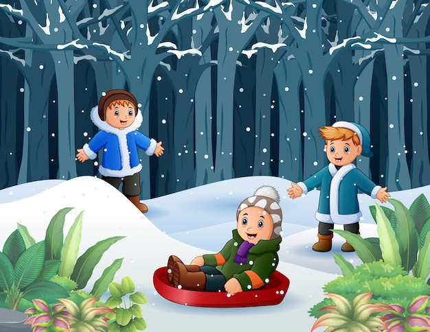 Niños felices jugando al aire libre en invierno