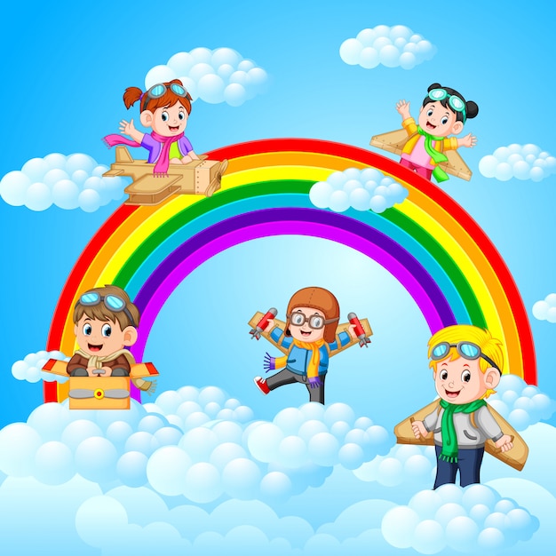 Niños felices jugando avión de cartón con fondo de paisaje de cielo