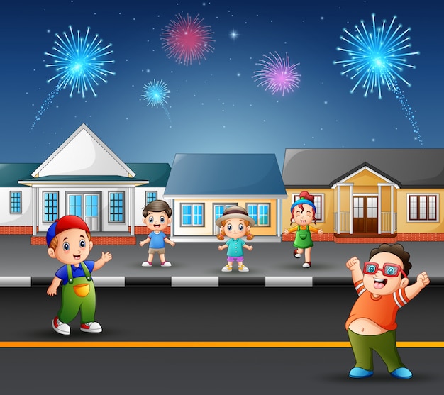 Niños felices jugando en la carretera con vistas de fuegos artificiales en el cielo