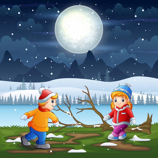 Niños jugando en el paisaje nocturno de invierno.