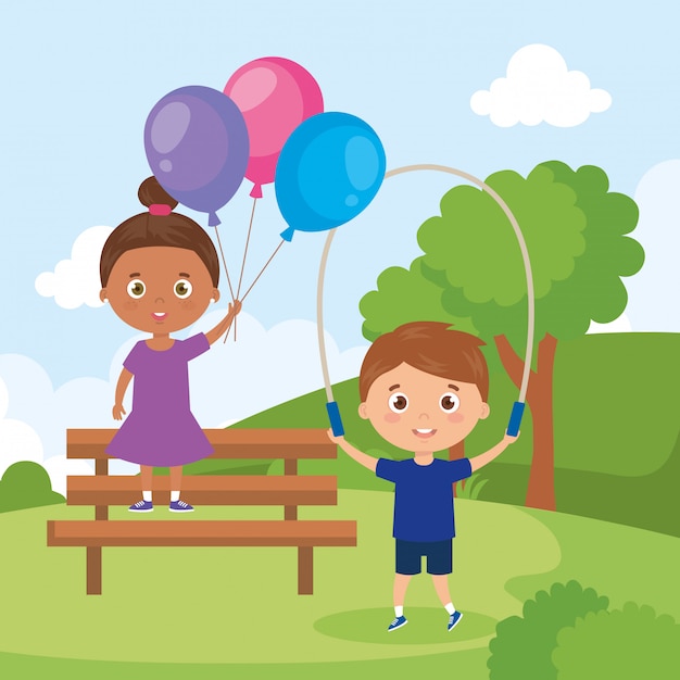 Los niños pequeños con globos de helio y saltar la cuerda en el paisaje del parque