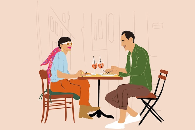 Pareja sentada en la terraza del restaurante en la calle de la ciudad