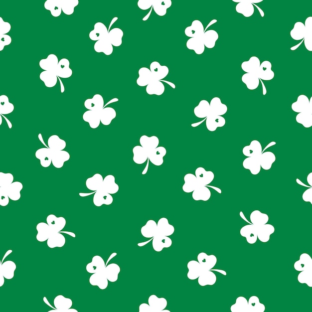 Un pequeño trébol blanco está esparcido sobre un fondo verde feliz día de San Patricio patrón sin costuras