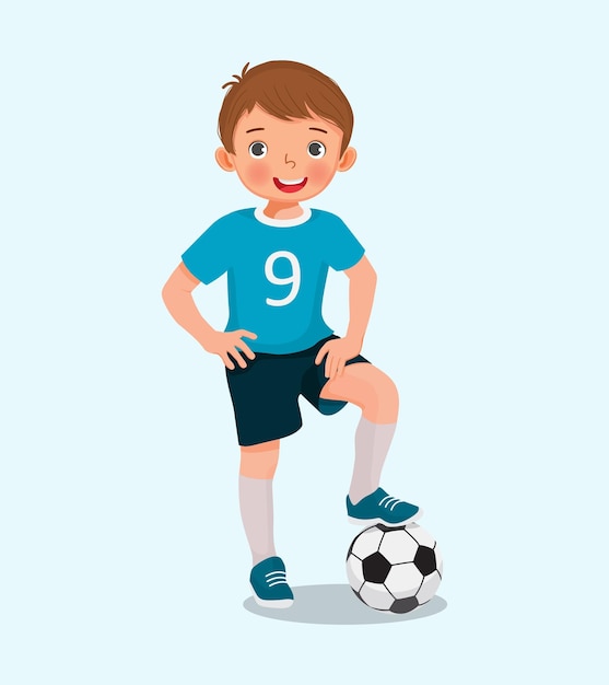 Retrato de niño lindo en ropa deportiva posando con una pelota de fútbol posando con la mano en la cintura