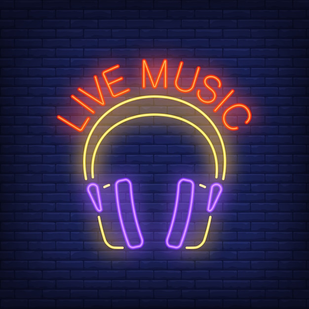 Señal de neón de música en vivo. Auriculares en el fondo de la pared de ladrillo. Anuncio brillante de la noche.