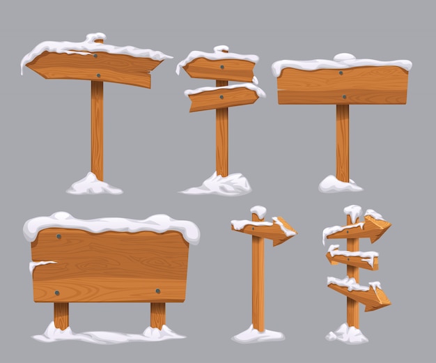 Señales direccionales de madera con nieve