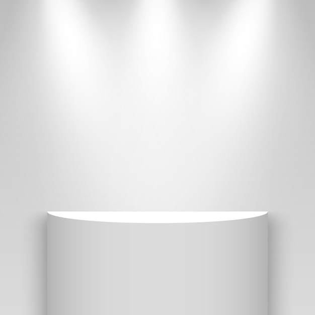 Stand de exposición blanco, iluminado por focos. Pedestal. Estante.
