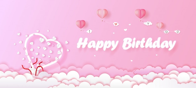 Tarjeta de cumpleaños y caja de regalo corazón blanco sobre fondo rosa.