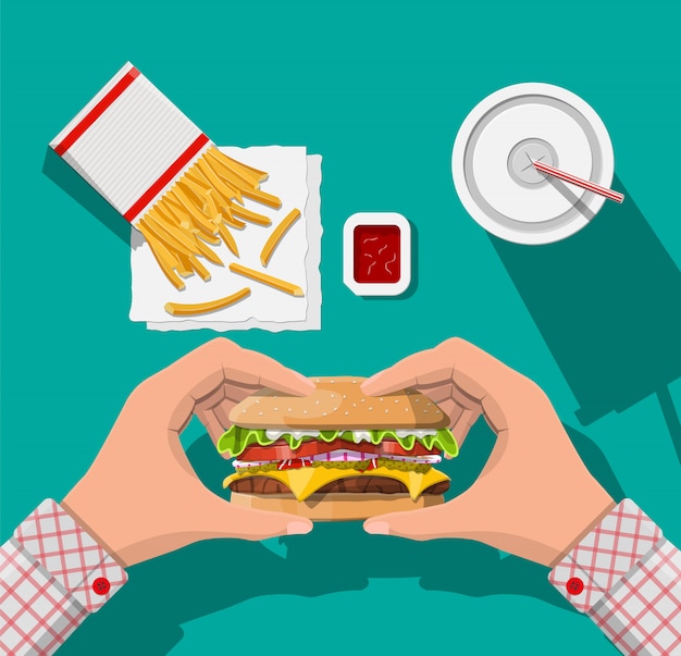 Taza de cola con papas fritas y hamburguesa con queso.