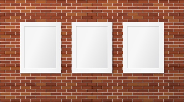 Tres marcos blancos en una pared de ladrillos