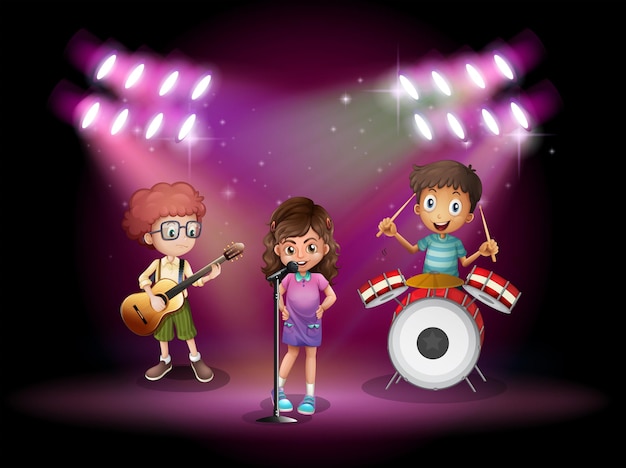 Tres niños tocando música en el escenario.