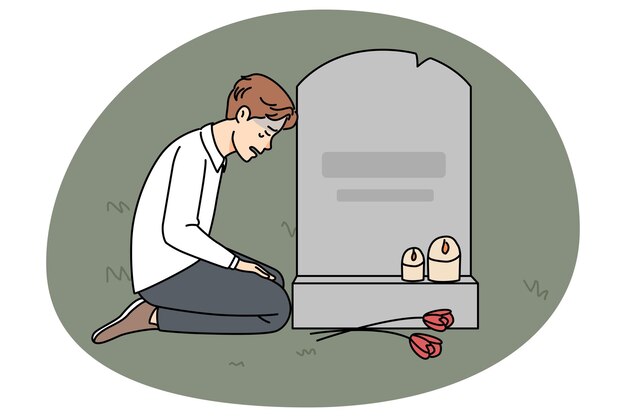 Triste hombre llorando en la tumba en el cementerio