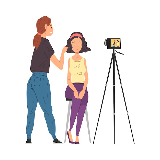 Visagista profesional haciendo maquillaje para el cliente y grabando video blog con cámara en trípode