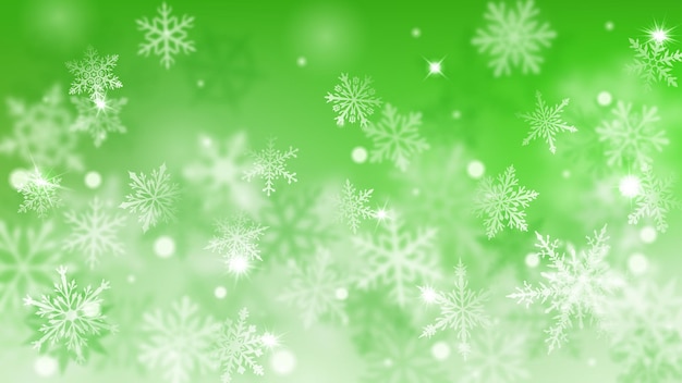 Christmas blurred background of complex defocused big and small falling snowflakes in green colors with bokeh effect