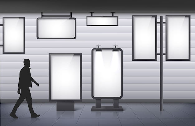 Man walking past blank advertising displays