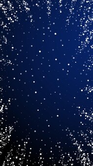 Zufällige weiße punkte weihnachtshintergrund. subtile fliegende schneeflocken und sterne auf dunkelblauem hintergrund. tatsächliche winter-silber-schneeflocken-overlay-vorlage. fesselnde vertikale abbildung.