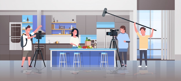 Betreiber mit Videokamera Aufzeichnung Lebensmittel Blogger Frau, die leckere Gerichte Videografen mit professionellen Geräten Kochen Blog Filmproduktionskonzept Küche Interieur horizontal zubereiten