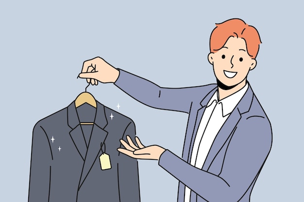 Ein mann hält eine neue jacke mit einem etikett und bietet an, geschäftskleidung für manager oder angestellte zu kaufen. ein mann arbeitet als verkäufer oder reinigungsangestellter und schaut mit einem lächeln auf den bildschirm und gibt dem kunden eine jacke auf dem anhänger