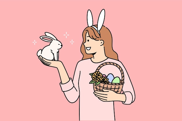 Ein teenager, das ostern feiert, hält geschmückte eier in einem korb und ein kleines kaninchen
