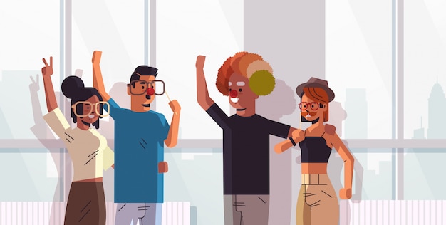 Erster April Narrentag Mix Race Kollegen tragen lustige Brille Schnurrbart und Clown Hut Urlaub Feier Konzept modernes Büro Interieur horizontales Porträt