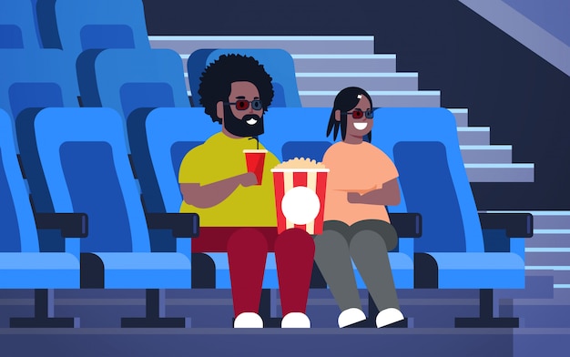 Fettes paar in 3d-gläsern, die film ansehen, der im kino mit popcorn und cola übergewichtige afroamerikanische mannfrau sitzt, die datum hat und über neue komödie flach volle länge horizontal lacht