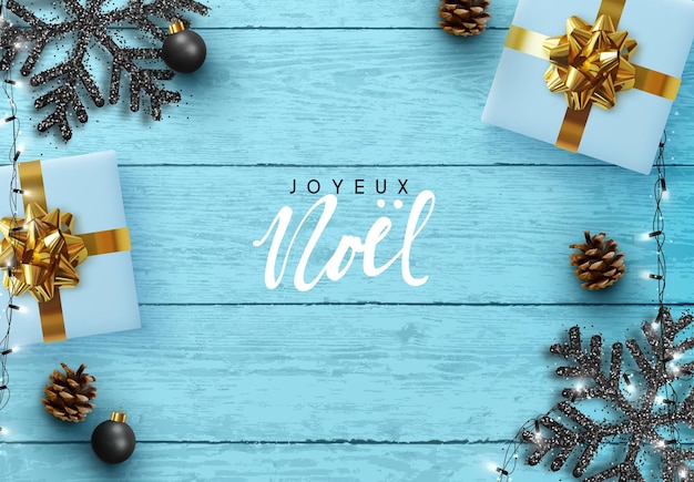 Französischer text joyeux noel. weihnachtsblauer hintergrund. holzplankenstruktur, schwarze schneeflocken, realistischer tannenzapfen, dekorative kugeln, geschenkboxen, weihnachtliche hellweiße girlande. flache lage, draufsicht