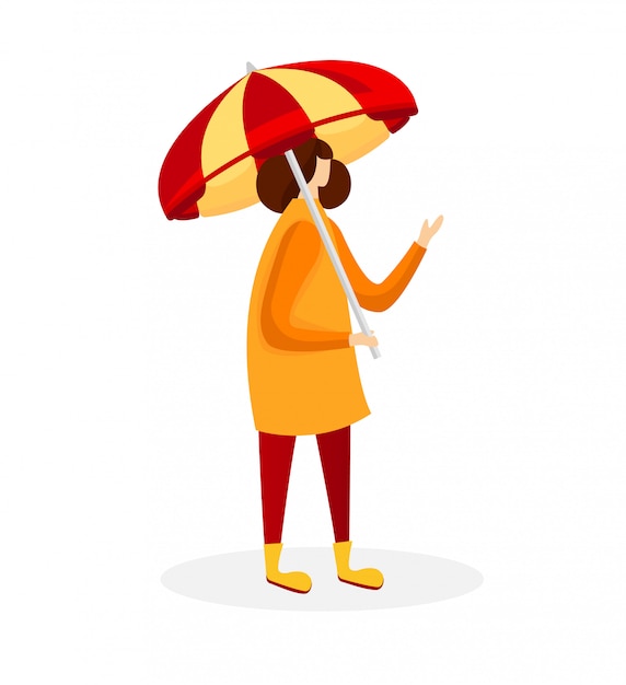 Frau im umhang und in den gummistiefeln, die regenschirm halten.
