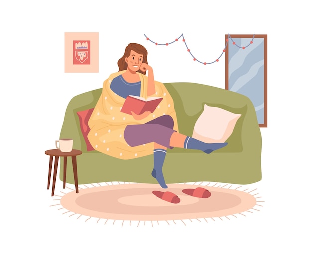 Frau liest ein Buch auf dem Sofa und trinkt ein warmes Getränk am Tisch