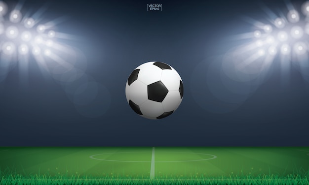 Fußballfußball und grünes Gras des Fußballfeldstadionhintergrunds