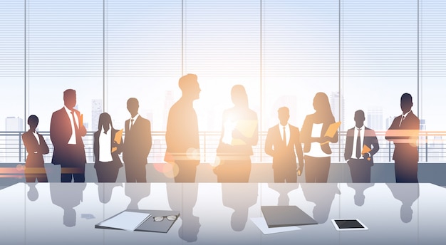 Geschäftsleute gruppieren Sitzung Silhouetten-modernes Bürogebäude-panoramisches Innenfenster