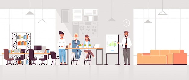 Geschäftsmann, der finanzdiagramm auf flipchart zum geschäftsmann-team bei der konferenzsitzungsschulungspräsentationsmoderne zusammenarbeitenden raumbüro-innenraum präsentiert