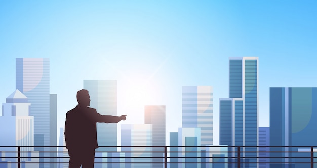 Geschäftsmann Silhouette über moderne Stadt stehen
