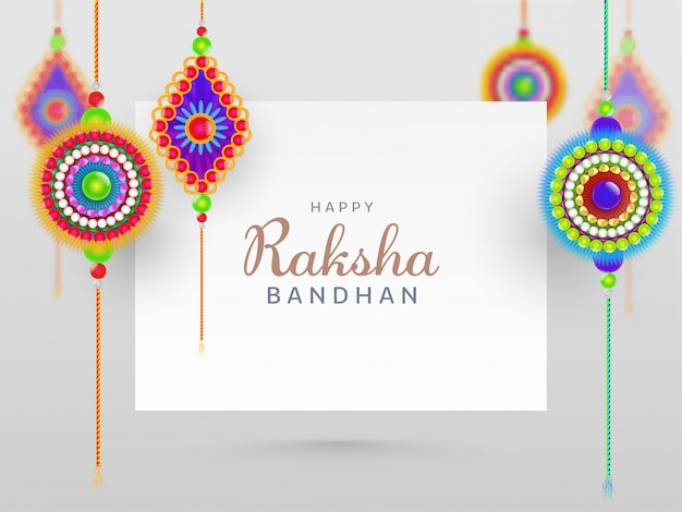 Glückliches Raksha Bandhan Konzept mit schönen Rakhis hängen am weißen Hintergrund.