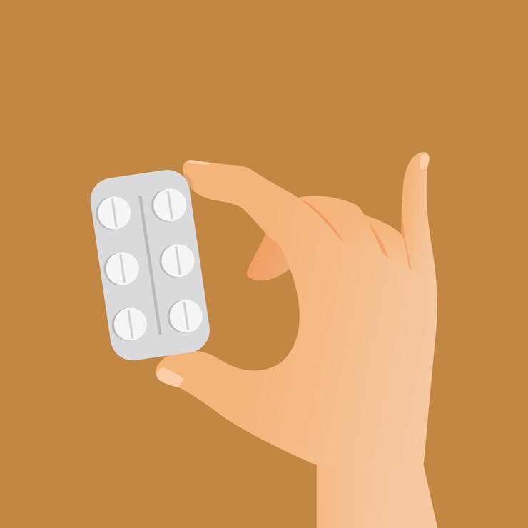Hand, die Plastikblister mit weißen runden Pillen hält