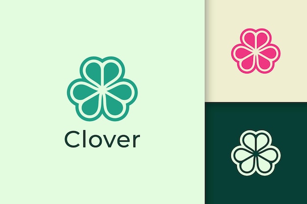 Kleeblatt-logo in abstrakter form mit grüner farbe steht für glück oder kräuter
