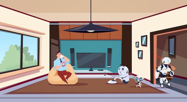 Mann, der im Wohnzimmer sich entspannt, während Gruppe Roboter-Haushälterinnen Haus säubern