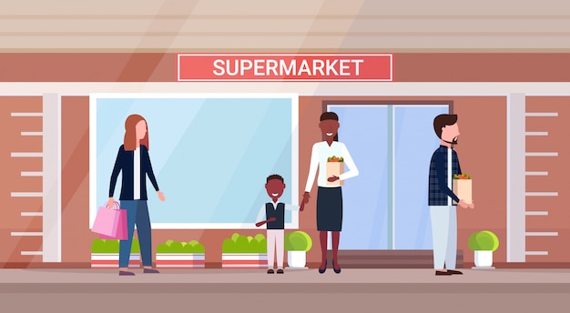 Mischen sie rassenmenschen beim halten von einkaufstüten mit lebensmittel-comicfiguren, die im freien modernes lebensmittelgeschäft supermarkt außen horizontal stehen