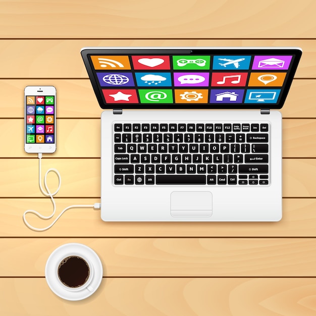 Smartphone mit Laptop und Tasse Kaffee auf dem Tisch verbunden