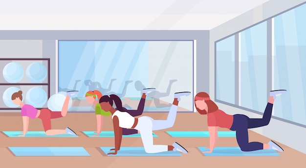 Vektor sportliche frauen, die fitnessübungen auf yogamattenmischungsrassenmädchen machen, die im fitnessstudio trainieren gesundes lebensstilkonzept flaches modernes gesundheitsklubstudio innen horizontal