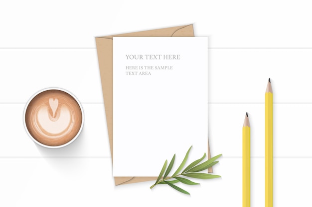 weißes Kompositionspapier mit Kaffee- und Estragonblatt auf hölzernem Hintergrund