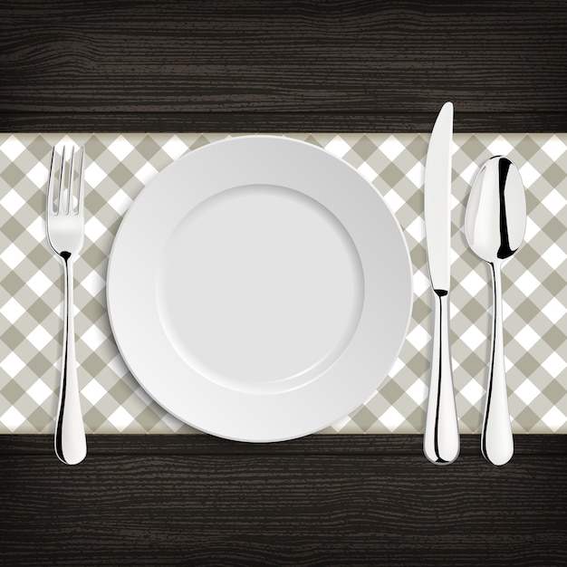 plate with spoon, khife and fork on a wood table