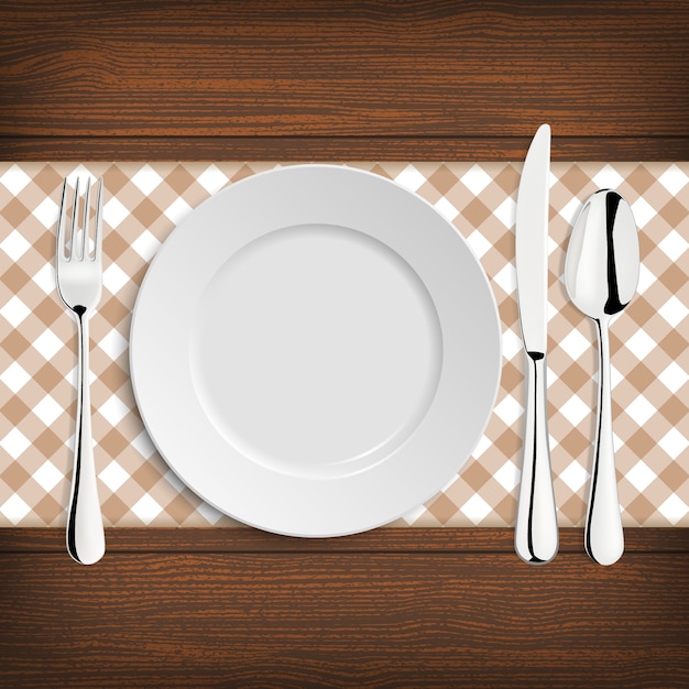 plate with spoon, khife and fork on a wood table