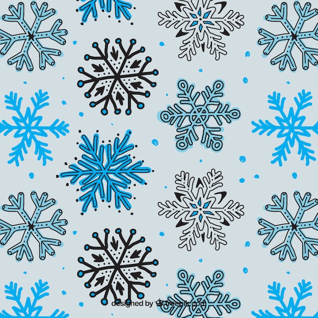 Vetor grátis desenhadas mão flocos de neve padrão