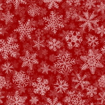 Padrão sem emenda de natal de muitas camadas de flocos de neve de diferentes formas, tamanhos e transparência. branco em fundo vermelho