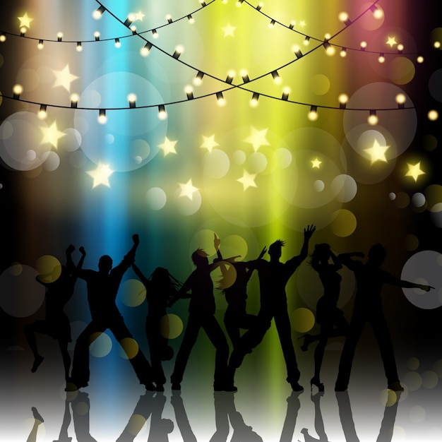 Silhouettes of people dancing on a bokeh lights background