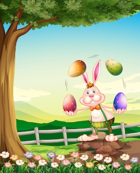 Um coelho malabarismo com os ovos de páscoa