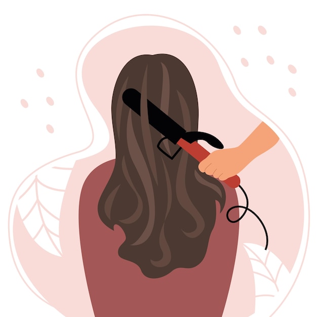 A mulher está sentada de costas com lindos cabelos castanhos cacheados. Ondulando o cabelo em um ferro de ondulação