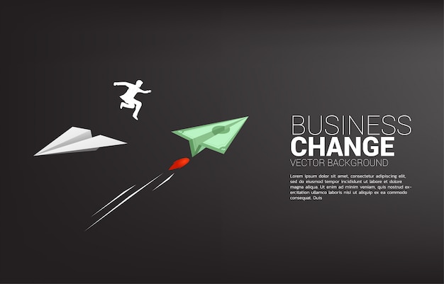 A silhueta do homem de negócios salta do avião de papel do origami branco ao dinheiro da cédula para a direção da mudança. conceito de negócio de mudar a direção do negócio. missão de visão da empresa.