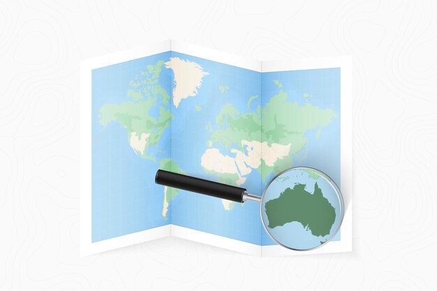 Ampliar a Austrália com uma lupa em um mapa do mundo dobrado